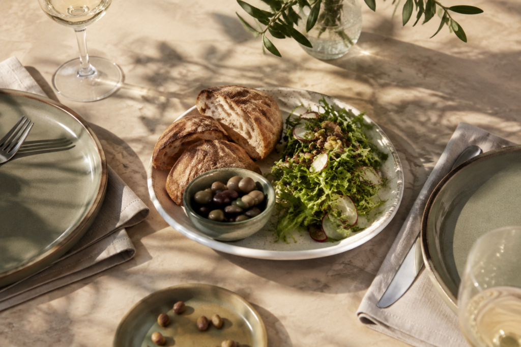 Shared bread, olives and salad with two place settings