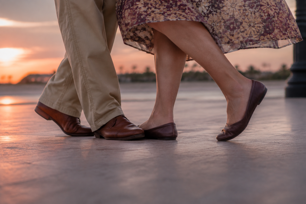 Close low angle on two adults comfortable flat dance shoes taking a simple coordinated step on smooth outdoor paving